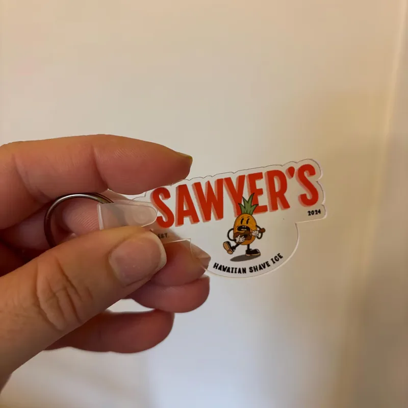 Die-cut Sawyer's Hawaiian Shave Ice logo keychain on clear acrylic